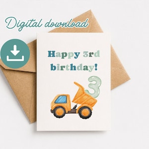 May include: A birthday card featuring an orange dump truck and a number 3 balloon illustration. The card says "Happy 3rd birthday!" in blue and teal text. A brown envelope is visible behind the card.