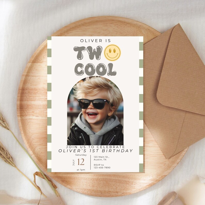 May include: A white invitation card with green and white checkered border. The card has a photo of a boy wearing sunglasses and a black leather jacket. The text on the card reads "Oliver is Two Cool" with a yellow smiley face. The invitation details include the date, time, and location of the event.