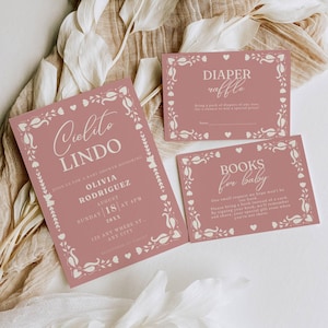 Könnte beinhalten: Rosa-weiße Babyparty-Einladung mit floralem Design. Die Einladung lautet "Cielito Lindo" und enthält den Namen Olivia Rodriguez, das Datum 18. August und die Uhrzeit 16:00 Uhr. Es gibt auch zwei Karten für eine Windel-Tombola und eine Buchwunschliste.