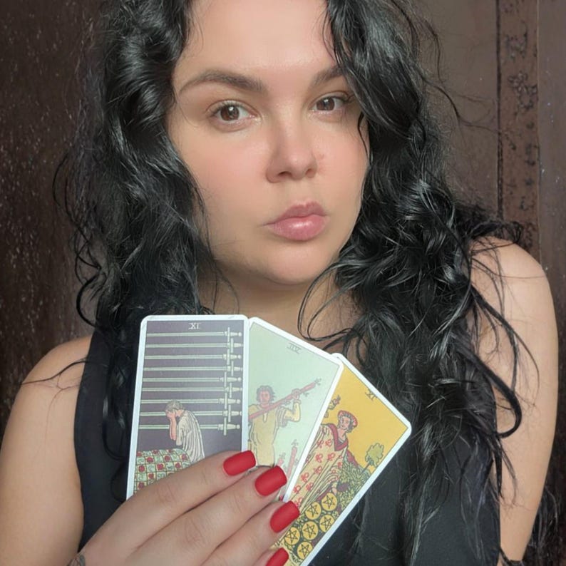 May include: Three rectangular tarot cards held in a hand with red nail polish. The left card is the Nine of Swords, the middle card is the Six of Wands, and the right card is the Six of Pentacles, each featuring detailed illustrations and Roman numerals.