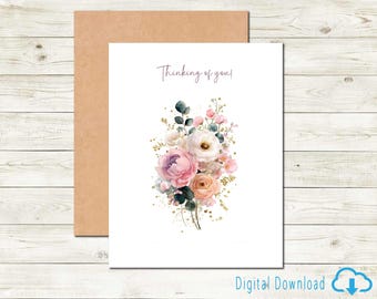Puede incluir: Una tarjeta de felicitación blanca con un diseño floral en acuarela y un sobre marrón. La tarjeta presenta un ramo de flores rosas, melocotón y blancas con hojas verdes y detalles dorados. El texto "Thinking of you!" está escrito en la parte superior.