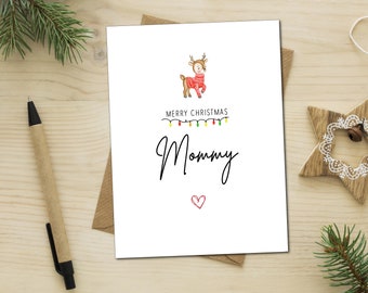 Op de afbeelding: Een witte kerstkaart met een cartoon rendier dat een rode trui draagt. De kaart zegt "Merry Christmas Mommy" met een rood hart.