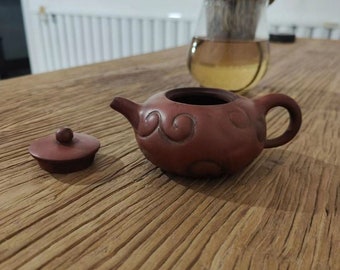 Handwerkliche Ton-Teekanne mit Wirbelmuster. Handgefertigte Keramik-Teekanne. Rustikale Teekanne aus rotem Ton – elegante handgefertigte Keramik