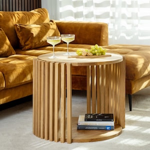 Natural solid oak fluted round coffee table. Coffee table is 2-tiered Japandi style that fits perfectly for scandinavian interiors, modern or mid century modern interious.