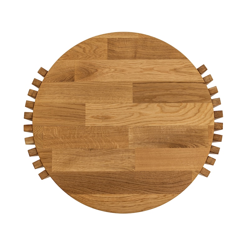 May include: A round wooden table top with a unique design. The top is made of light brown wood and has a circular pattern of small squares.