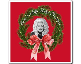 May include: A square sticker with a red background features a portrait of a woman with blonde hair, surrounded by a green wreath with the text "Have a Holly Dolly Christmas." A red bow is at the bottom of the wreath.