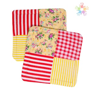 Peut inclure: Deux dessous-de-verre en tissu patchwork rouge et jaune avec des motifs différents. Les dessous-de-verre sont carrés et ont une bordure cousue.