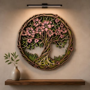May include: A circular, multi-layered wooden wall art piece featuring a tree with pink blossoms and green foliage. The intricate design is composed of stacked wood cutouts, creating a three-dimensional effect within a circular frame.