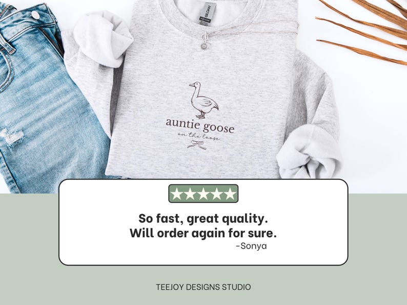 Może przedstawiać: Jasnoszara bluza z napisem "auntie goose on the loose" i ilustracją gęsi. Bluza jest połączona z niebieskimi dżinsami. Widoczna jest r&oacute;wnież recenzja klienta.