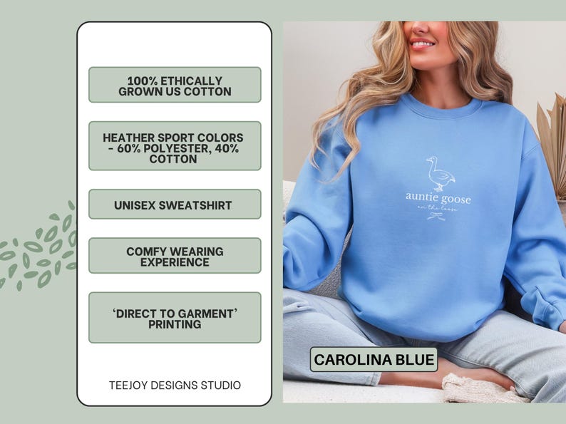Może przedstawiać: Niebieska bluza unisex w kolorze Carolina z napisem "auntie goose" i grafiką gęsi. Bluza wykonana jest z mieszanki bawełny i poliestru. Na zdjęciu widnieje r&oacute;wnież napis "100% etycznie uprawiana bawełna z USA".