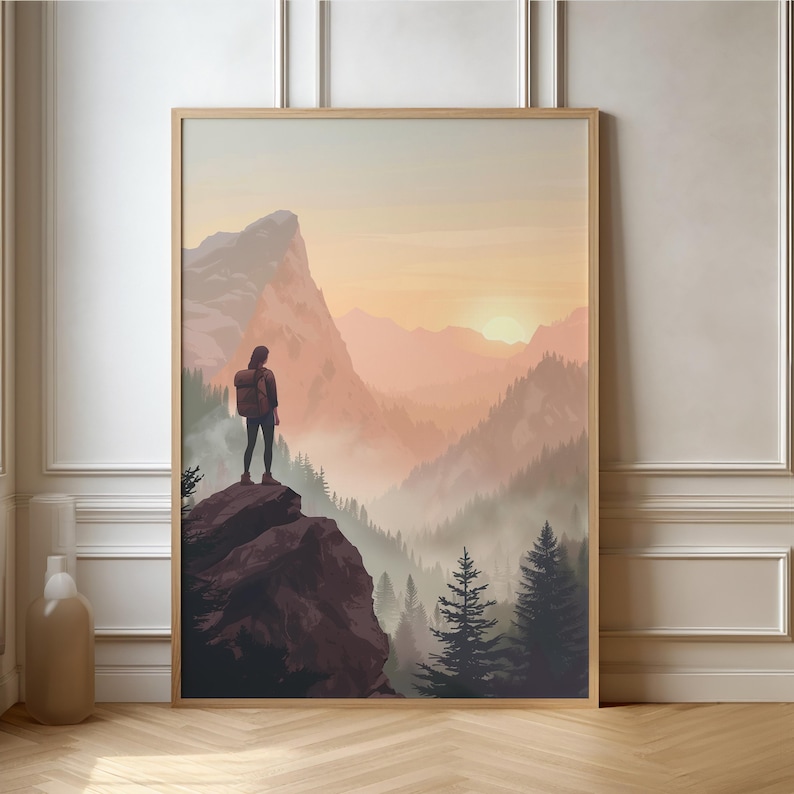 K&ouml;nnte beinhalten: Eine Frau steht auf einem felsigen Kliff mit Blick auf ein nebliges Tal mit einer Bergkette im Hintergrund. Die Sonne geht unter und taucht die Landschaft in ein warmes Licht.