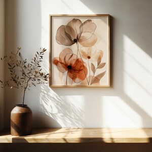 K&ouml;nnte beinhalten: Ein gerahmter Kunstdruck mit abstrakten Blumen im Aquarellstil. Das Kunstwerk verwendet Braun-, Orange- und Cremet&ouml;ne mit zarten Strichzeichnungen und sanften Farbabstufungen. Der Rahmen ist aus hellem Holz gefertigt.