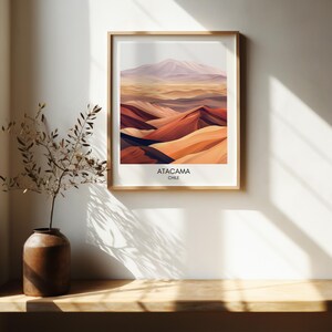 Puede incluir: Una impresi&oacute;n enmarcada de un paisaje abstracto colorido con el texto "ATACAMA CHILE" en la parte inferior. El paisaje es una mezcla de tonos naranja, rojo y marr&oacute;n, con una monta&ntilde;a morada en el fondo.