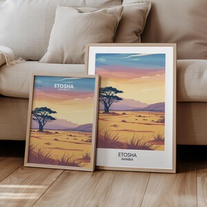 May include: Two framed landscape prints of the Etosha National Park in Namibia. The top print shows a sunset over a savanna with a lone acacia tree in the foreground. The bottom print shows a similar scene with a different perspective and a more detailed view of the savanna.