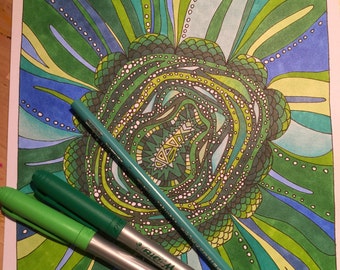 May include: A close-up of a green and blue mandala-like design with a ladybug on a green stem. Two green and silver markers are lying on top of the design.