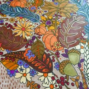 May include: A hand-painted illustration of a heart-shaped arrangement of fall foliage, flowers, and pumpkins. The design features a variety of colors, including orange, yellow, red, brown, and green. The background is a light brown with a dotted pattern.