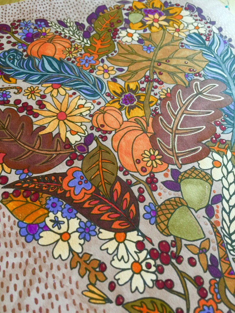 May include: A hand-painted illustration of a heart-shaped arrangement of fall foliage, flowers, and pumpkins. The design features a variety of colors, including orange, yellow, red, brown, and green. The background is a light brown with a dotted pattern.