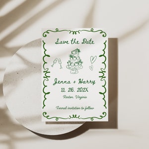 Può includere: Carta di salvataggio della data con calligrafia verde. La carta presenta una torta nuziale, bicchieri di champagne e cuori. Il testo recita "Save the Date", "Jenna + Harry", "11. 26. 202X", "Reston, Virginia" e "Formal invitation to follow".