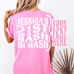May include: Pink t-shirt with white text that says "Jessica's 21st Bash in Nash" in a retro font. The text is in a curved shape.