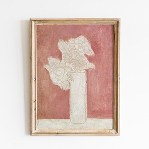 May include: A framed painting of a white flower arrangement in a white vase against a red background.