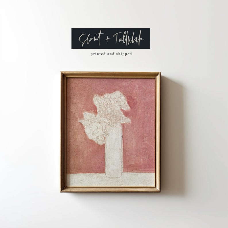 May include: A framed painting of a white flower arrangement in a vase against a pink background. The painting is titled "Scout + Tallulah" and has the text "printed and shipped" below the title.
