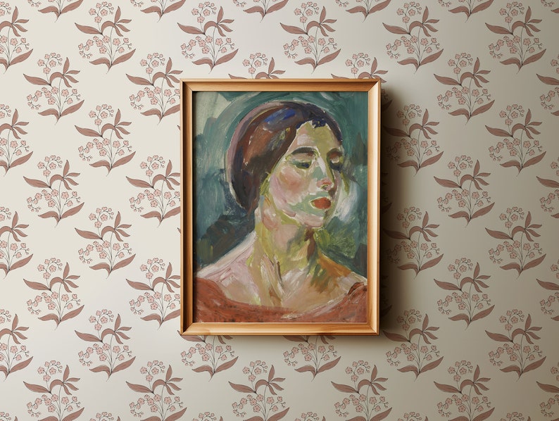 May include: A framed painting of a woman's portrait. The woman has dark hair and is wearing a light blue headscarf. The painting is set against a light green background with brushstrokes visible. The frame is a simple gold color.