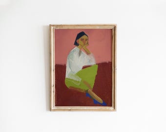 May include: Framed art print featuring a seated figure in a white shirt and green skirt, with blue shoes. The figure is set against a pink and maroon background. The artwork is enclosed in a gold-toned frame, adding a touch of elegance.