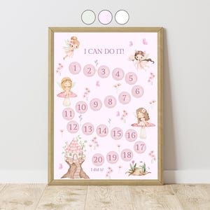 May include: A framed pink chart with the text "I CAN DO IT!" and numbers 1-20. The chart features illustrations of fairies, flowers, and a fairy house. The words "I did it!" are at the bottom.