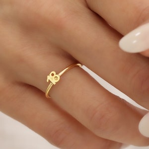 May include: A gold ring with the number 18 on it.