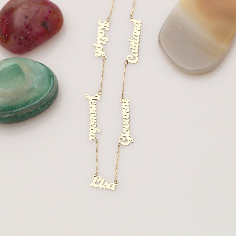 May include: Gold necklace with five personalized name tags. The names are Lisa, Giovanni,  Jenaueka,  Caitlin, and Hadley.