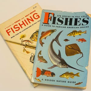 May include: Two vintage softcover books titled Fishing: A Guide to Fresh and Salt-Water with 650 illustrations and Fishes: A Guide to Familiar American Species with 278 species in full color. Both books feature detailed fish illustrations.