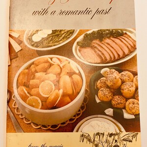 May include: Vintage cookbook cover titled "75 Easy Yam Recipes with a romantic past." The cover features images of prepared dishes, including a bowl of yams with orange slices. The bottom of the cover reads "...from the magic Evangeline Land of Louisiana."