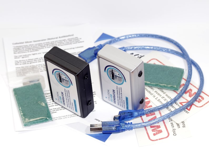 May include: Two colloidal silver generators, one black and one silver, with blue USB cables and green pads. The devices have labels with text and a circular design. Additional printed materials are also present.