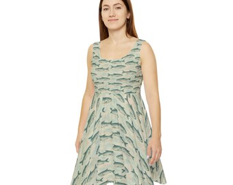 May include: A sleeveless dress featuring a repeating pattern of fish in shades of blue and gray on a light beige background. The dress has a flared skirt and a scoop neckline. The fabric appears to be a lightweight material.