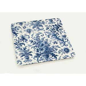 May include: Square coaster with a blue and white floral pattern. The design features a detailed arrangement of flowers and foliage in a classic, elegant style. The coaster is likely made of a durable material.