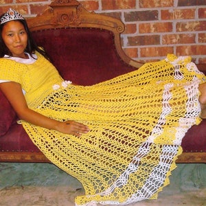 May include: A woman wearing a yellow crocheted dress with white trim sits on a vintage chaise lounge. She is wearing a tiara and has her feet up on the chaise.
