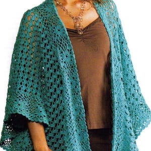 Puede incluir: Un cárdigan de crochet de color turquesa con un patrón de encaje. El cárdigan está abierto por delante y tiene un corte holgado.