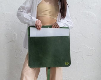 May include: A green leather portfolio with a white sheet of paper inside and the initials "SD" embossed on the front.