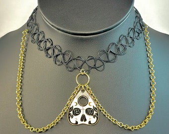May include: A black choker necklace with a gold chain and a white and black Ouija board pendant. The pendant has the words "YES" and "NO" on it.