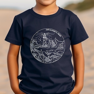 May include: A navy blue t-shirt with a white graphic of a lighthouse, whale, and waves. The text "Cape Elizabeth Maine" is printed on the graphic.