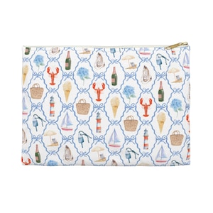 May include: A rectangular white pouch with a gold zipper, featuring a repeating pattern of nautical elements. The pattern includes red lobsters, sailboats, ice cream cones, and blue hydrangeas, all set against a blue lattice design.