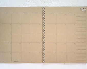 May include: A spiral-bound monthly calendar planner with tan paper pages. The open spread displays the month of May 2020 with a grid layout for days of the week, numbered dates, and a lined notes section on the right side. Text includes May 2020, Mother's Day, and Memorial Day.