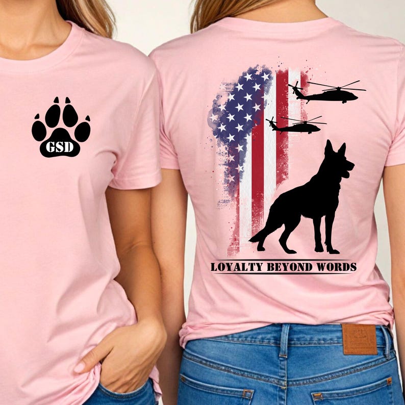 May include: Two pink t-shirts with graphic designs. One has a paw print and "GSD" text. The other features a black German Shepherd, helicopters, and an American flag design with the text "LOYALTY BEYOND WORDS."