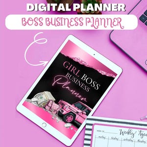 May include: A pink and black digital planner with the text "Girl Boss Business Planner" on the cover. The planner is open to a page with a pink car and a stack of money. The planner is on a pink surface with a black and white striped notebook.