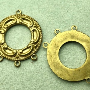 May include: Two gold-toned metal rings with decorative edges and multiple loops for attaching jewelry or other items.
