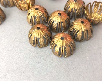 May include: A group of gold metal decorative embellishments with intricate floral designs. The embellishments are shaped like small domes with openwork patterns.