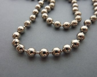 May include: A silver ball chain necklace with a smooth, shiny finish. The chain is made of small, round beads that are connected together.