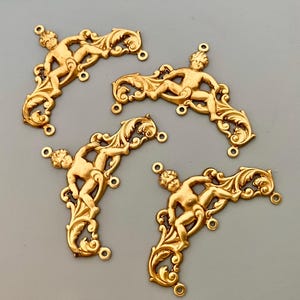 May include: Five gold-tone metal corner brackets with a cherub design. Each bracket has three holes for attaching to a surface.