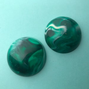 May include: Two round, green and white marbled cabochons. The cabochons have a swirling pattern of green and white.