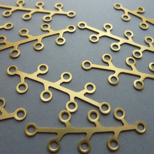 May include: A set of 10 gold-colored metal charms shaped like branches with small circles. The charms are perfect for jewelry making or crafting.